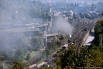 Bild des Monats November 2004. Bad Schlema. . Sachsen / Ein typischer Blick auf den Bahnhof Aue Mitte der 1980er Jahre: gut gefüllte Gütergleise, ein einfahrender Zug aus Richtung Zwickau, Rangierloks und das bekannte Bahnbetriebswerk. 10. Oktober 1987.