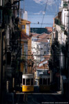 Mai 2005. Ascensor da Bica. Lissabon. São Paulo. Lissabon / Vom oben Endpunkt des  Ascensor  da Bica bietet sich dieser wundervolle Blick auf die Standseilbahn, die Stadt und den Tejo. Das durch eine Seitenstraße hereinbrechende Licht der tiefstehenden Sonne beleuchtet dabei effektvoll den berwärts fahrenden Wagen.